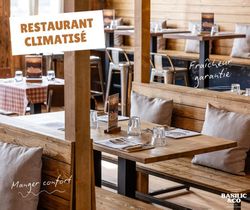 Intérieur de Basilic & Co à Cambrai avec tables en bois et chaises pour pizza à emporter et salades.