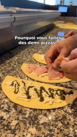 Préparation de demi-pizzas artisanales avec jambon et sauce sur plan de travail en granit.