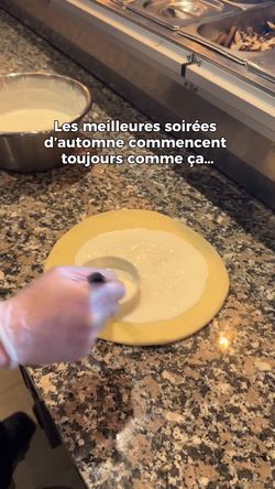 Préparation artisanale d'une pizza avec étalage de la sauce sur la pâte sur un comptoir en pierre
