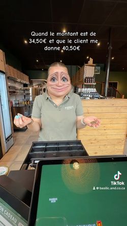 Employée du restaurant Basilic & Co à Cambrai derrière le comptoir avec boîtes à pizza et caisse enregistreuse visibles