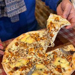 Pizza artisanale garnie de champignons, morceaux de viande et fromage fondant à Basilic & Co Cambrai.