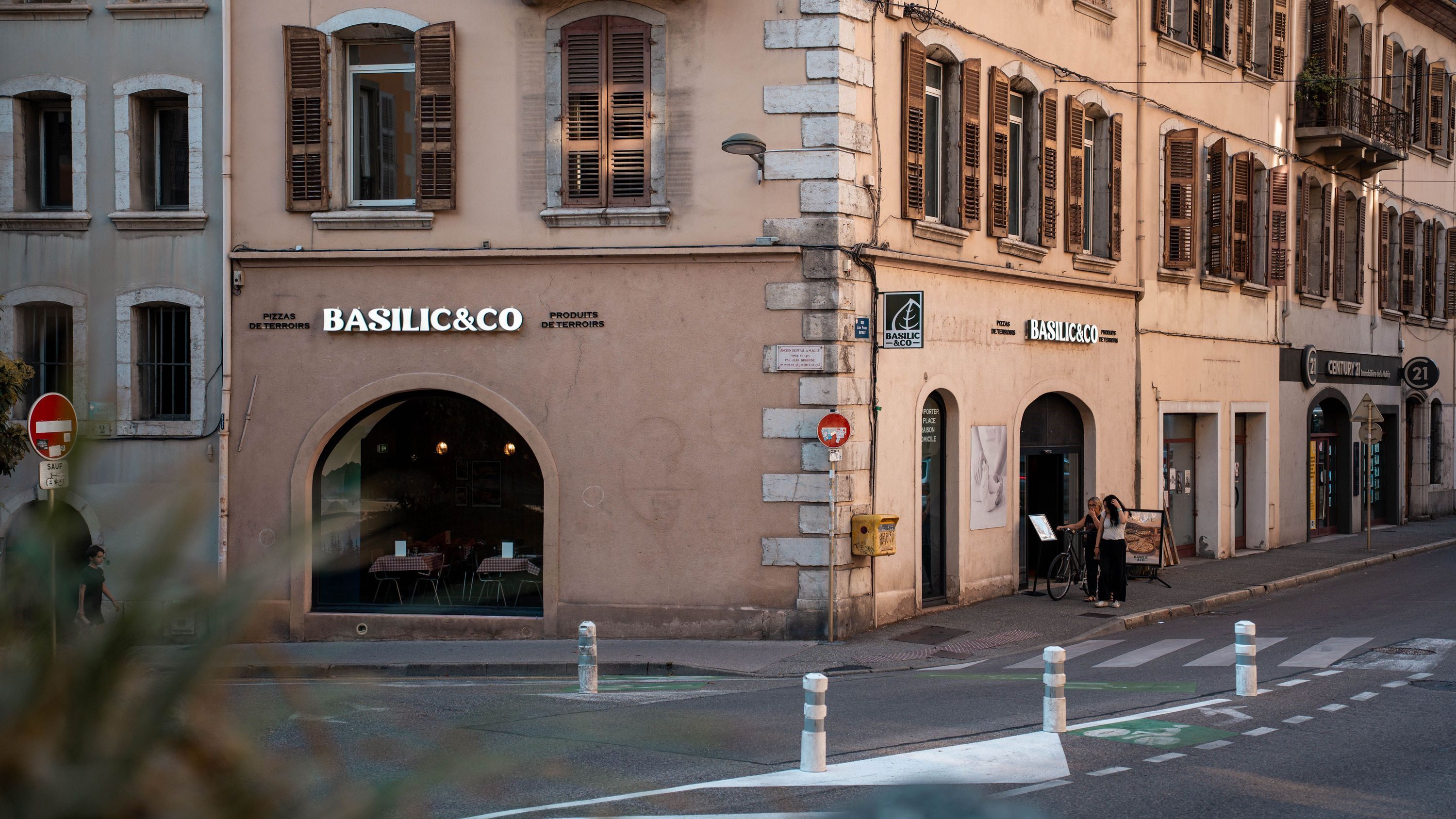 Façade du restaurant Basilic & Co à Chambéry avec fenêtres en bois et signalisation lumineuse sur le mur