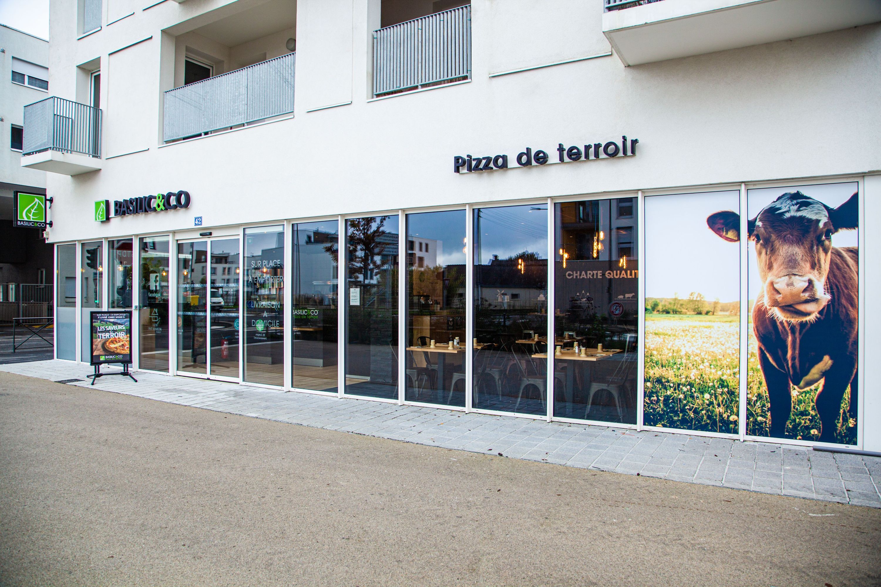 Basilic & Co, restaurant spécialisé dans les pizzas artisanales, offrant service à emporter et livraison.