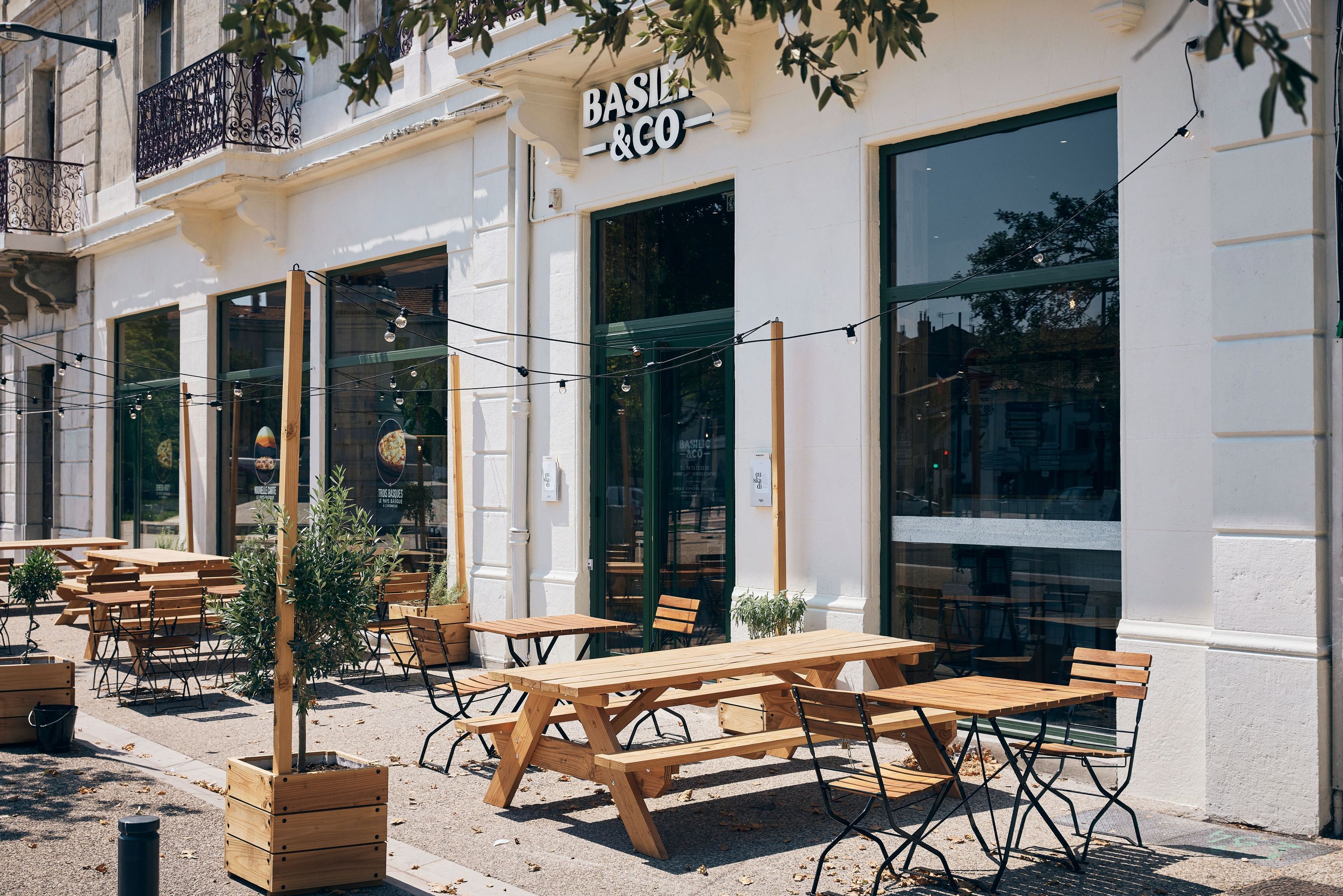 Basilic & Co à Valence propose une terrasse avec tables en bois et une décor sobre pour déguster des pizzas artisanales.