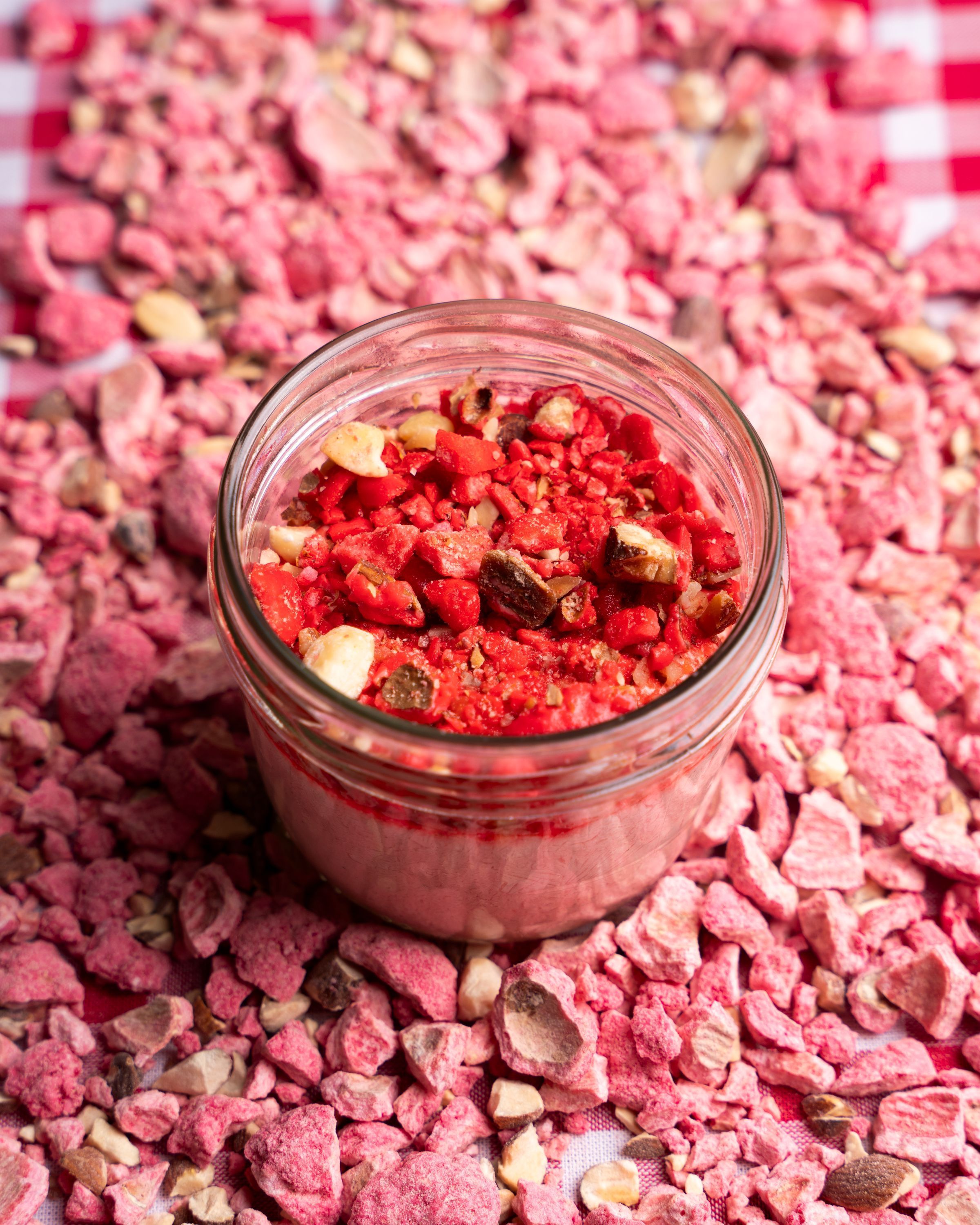 Mélange croquant rose dans un bocal en verre, composé de morceaux secs et de fruits à coque.