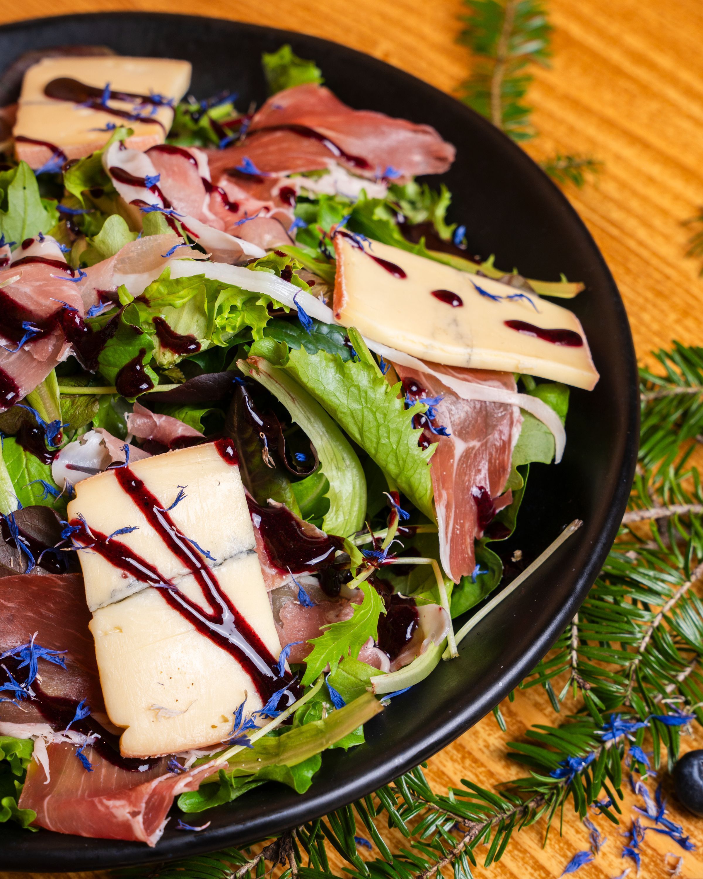 Salade garnie de jambon, fromage et vinaigrette sur un lit de verdures fraîches.