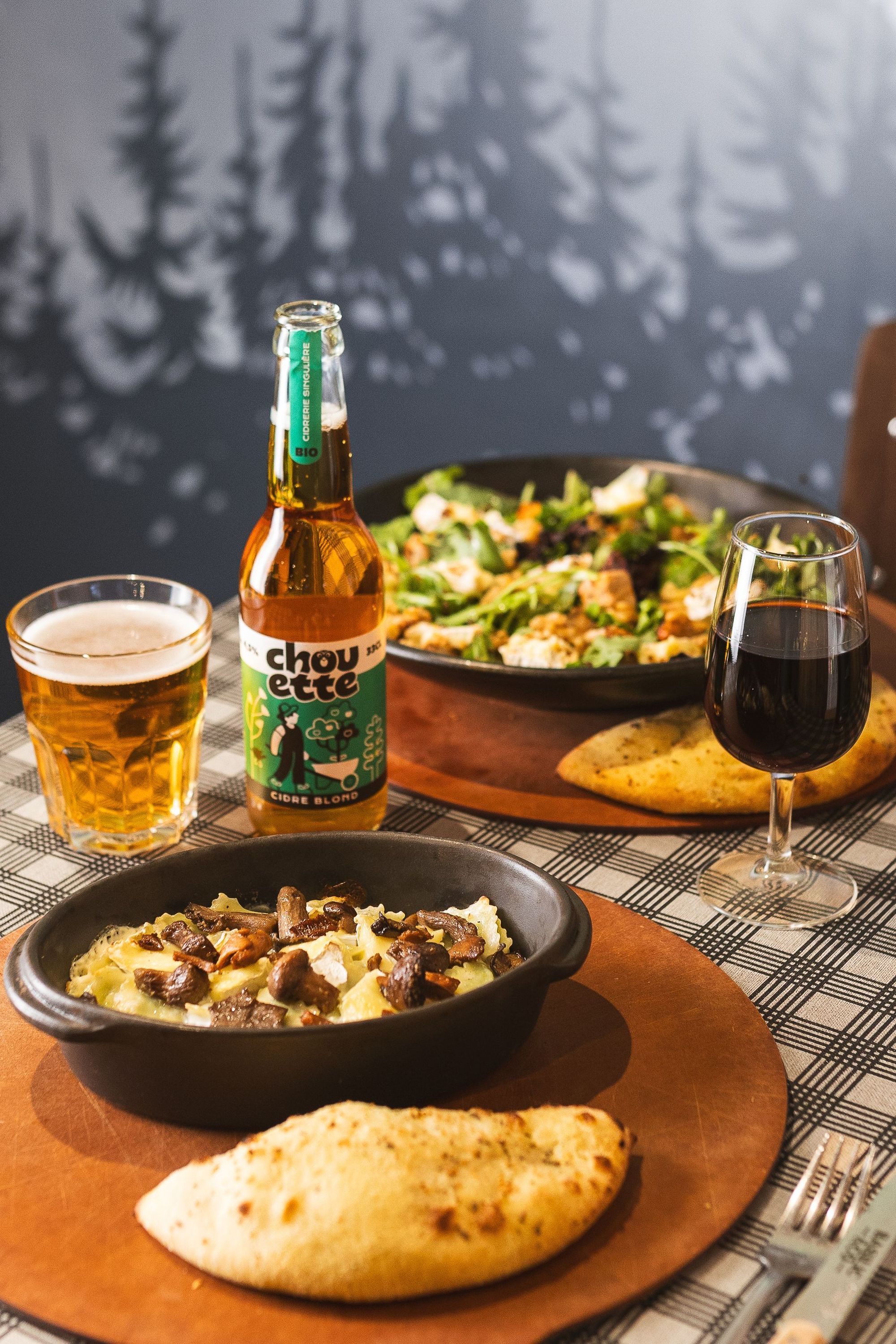 Assiette avec pizza artisanale, salade, bière et verre de vin dans un restaurant Basilic & Co à Tours.