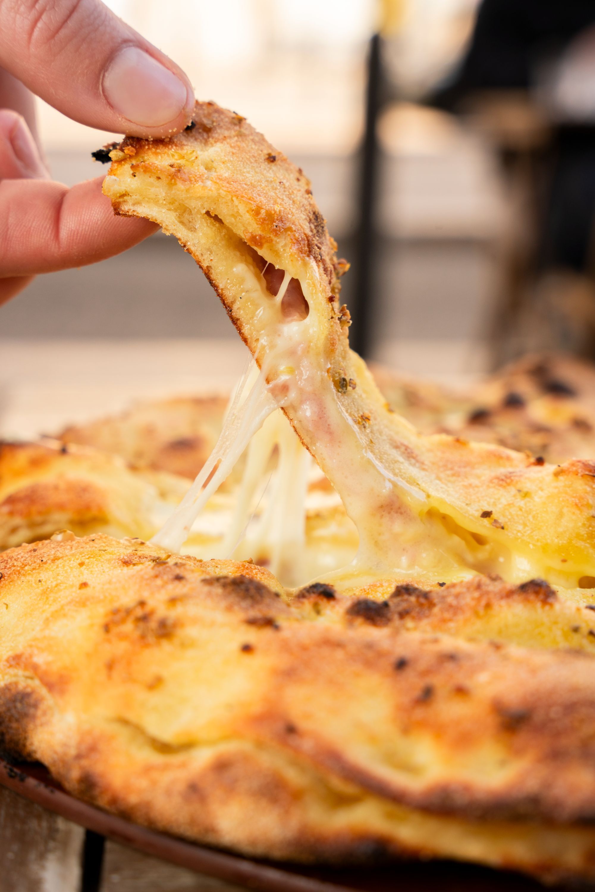 Pizza artisanale avec pâte dorée et fromage fondant tiré lors d'une dégustation à Basilic & Co Saint-Herblain.