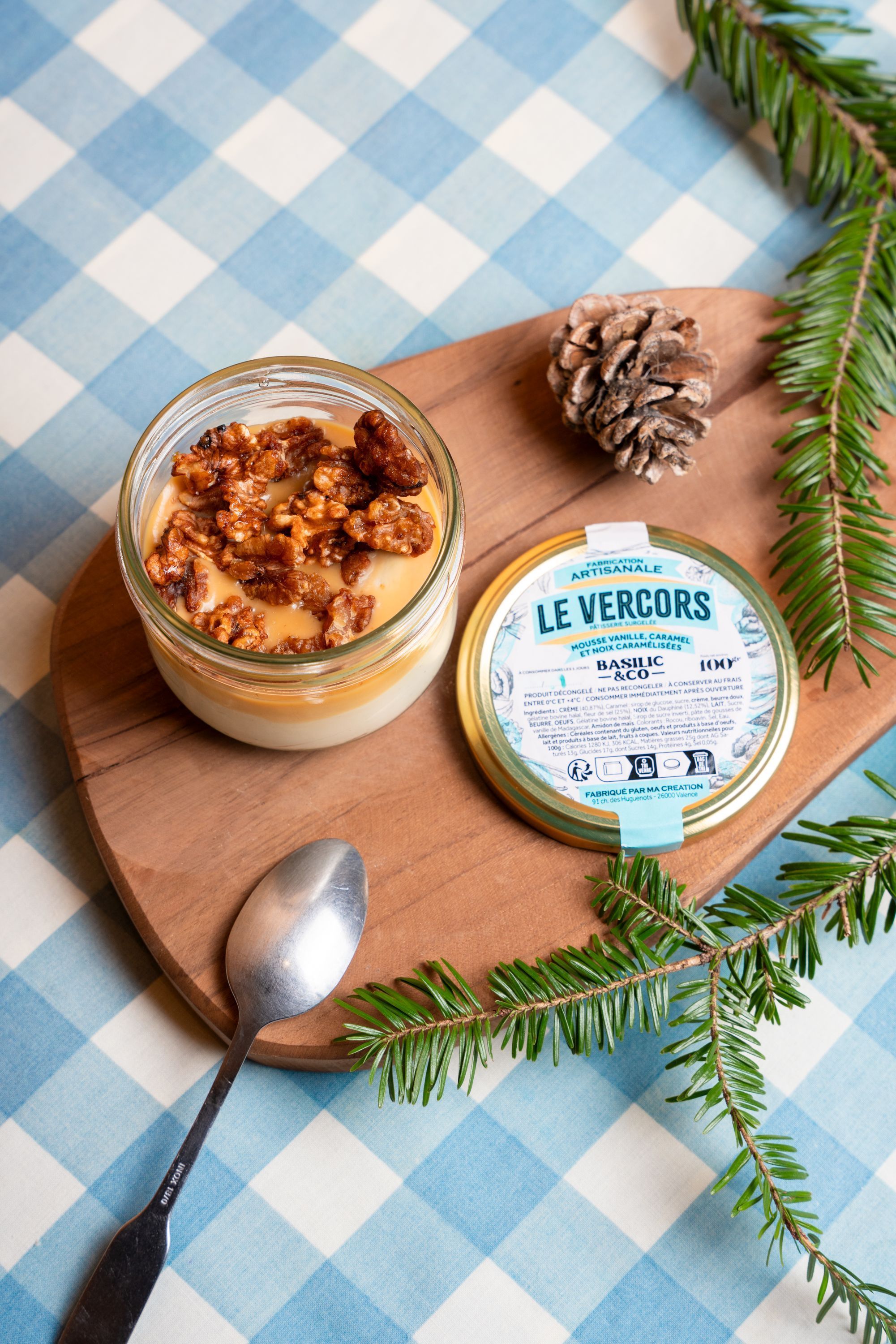 Dessert au verre avec mousse, noix et étiquette du fromage Le Vercors sur une planche en bois.